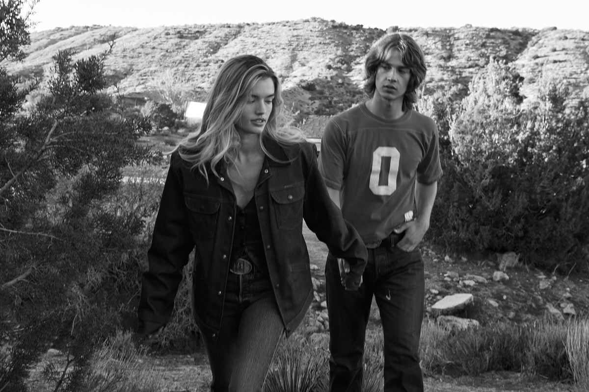 Two people walking together in a natural landscape wearing Caballero Buckles. Black and white photo, with the girl wearing the caballero bar buckle and the guy wearing a caballero rodeo buckle.